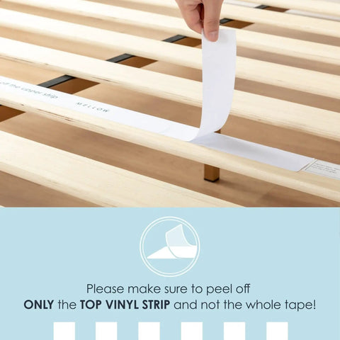 Hand peeling off the top vinyl strip from solid pine wood slats of the Queen Platform Bed Frame Low Profile Solid Pine Wood Rock Solid Heavy Duty 1000 Pound Capacity.