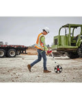 Worker using New 48-22-5112 for Milwaukee 12 In. Digital Measuring Wheel Red/Black on construction site.