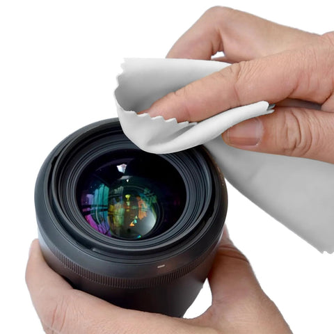Microfiber cleaning cloth, white, 7x6 in, used to wipe camera lens (close-up view)