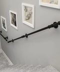 Built Like A Tank Wall Mount Handrail Stair Railing Bracket Complete Black Wrought Iron Kit Outdoor Indoor Step Support 19 Foot Long installed on wall next to art frames.