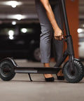 Person fixing a scooter in a garage with emphasis on the tire resembling Two Pack 4.10/3.50-4 Tire And Inner Tube With Bent Valve Stem