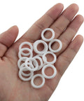 200 Piece Clear Plastic Curtain Rings For Roman Shades And Cafe Blinds Featuring Hardcore Durability on a hand, showing multiple white loops.