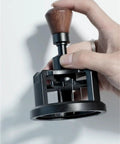 Premium Game Changer 58Mm Espresso Coffee Distributor With Magnetic Base And Precision Rotary Needles in hand, showcasing wooden handle.