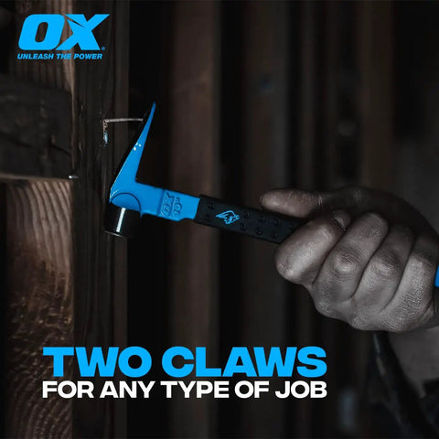10 Inch Cat Paw Pry Bar Nail Puller with Hammer Head and Rubber Grip in use, close-up of claw on wood surface in dim light.