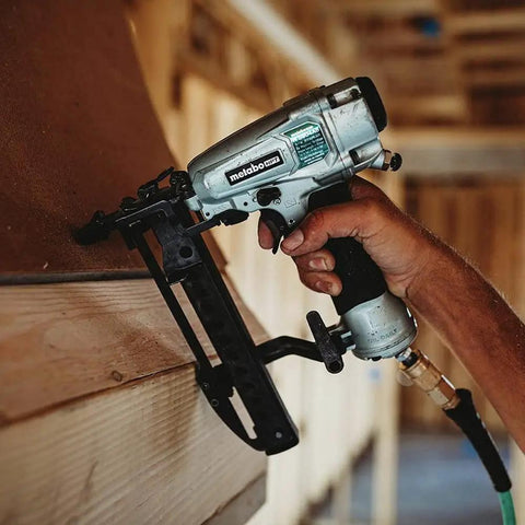 Pro Grade Finish Stapler For Trim And Furniture, 18 Gauge Pneumatic Nailer with metal body in use on wood trim.