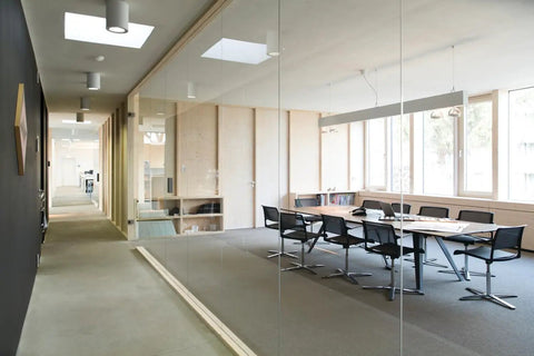 Modern office space with glass walls, featuring a Wall Mount Motion Sensor Switch With Dual Technology PIR Occupancy Sensor.