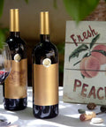 Premium Heat Shrink Wine Bottle Caps 100 Pack Flexible PVC Sealing Film on wine bottles with gold tops outdoors.