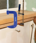 Four Pack 5 Inch Blue C Clamps Heavy Duty Iron Clamps for Woodworking, Welding, and Automotive Use Secure Brake Calipers DIY Projects Building Maintenance and More for DIYers, blue C-clamp on wood board