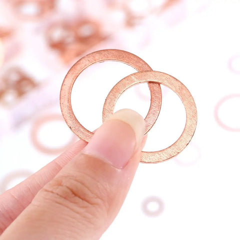 Close-up of hand holding Copper Metric Sealing Washer from 165 Pcs, 8 Sizes Flat Washers Kit for Electrical Connections.