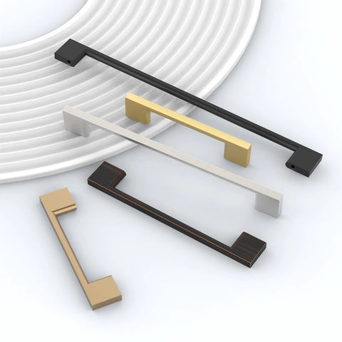 Variety of cabinet handles in brushed nickel, bronze, and gold finishes displayed on a plate