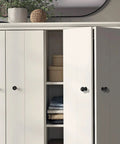 Matte Black Cabinet Knobs Four Pack With Wide Backplates shown on white bi-fold closet doors in modern interior
