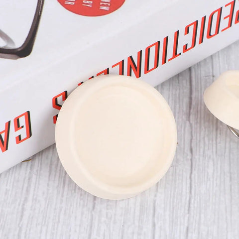 Close-up of 4pcs Rubber Sink Stopper Plug with Hanging Ring for Bathtub Drains, showing beige rubber plug on wooden surface.
