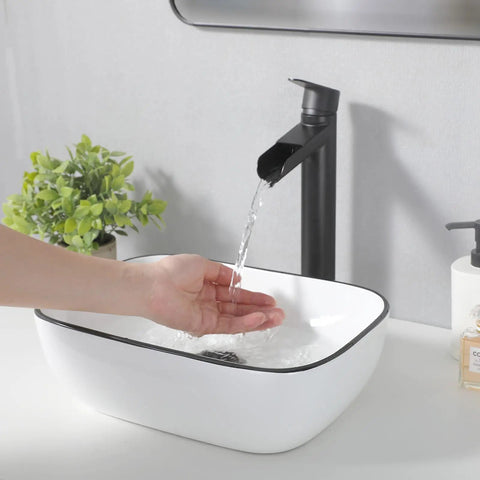 White Ceramic Oval Vessel Sink 23 By 16 Inch Modern Above Counter Bathroom Lavatory Vanity Basin with flowing water and hand