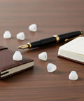 20 Pack White Nonstick Pen Bushings For Woodturning displayed on a desk with notebooks and a pen