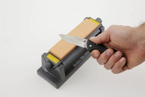 Tri Hone Stone Sharpening System Three Way Honing With 1000 Grit Fine Arkansas Stone, 800 Grit Medium, 300 Grit Coarse Stone, hand holding knife