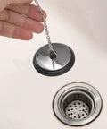 General Use Bath Tub Drain Stopper, with 10CM Chain being held above a sink drain, showcasing its chrome design.