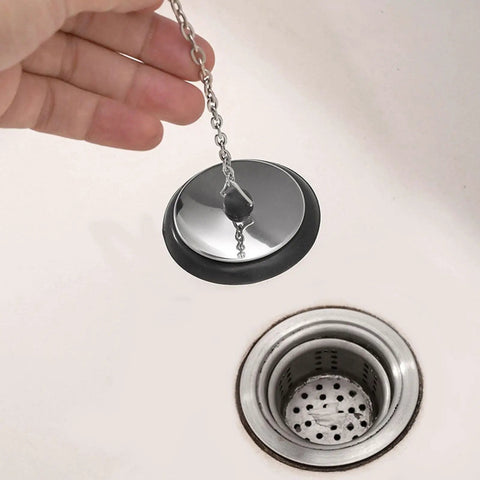 General Use Bath Tub Drain Stopper, with 10CM Chain being held above a sink drain, showcasing its chrome design.