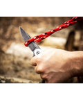 3 1/4 Inch Drop Point Pocket Knife With Aluminum Handle cutting rope, D2 Steel Blade, Smooth Ball Bearing Deployment shown in use