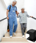 Heavy Duty Wall Mounted Handrail For Indoor Stairs Featuring An Extra Long Eleven Foot Black Steel Rail Built Tough For Rock Solid Grip And Keeps You Standing Tall, supporting an elderly woman down stairs.