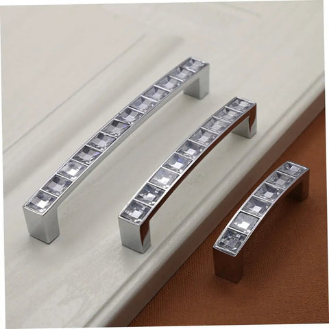 Crystal U Shaped Drawer Pull Handles in Bright Chrome with screws, set of three on wood surface