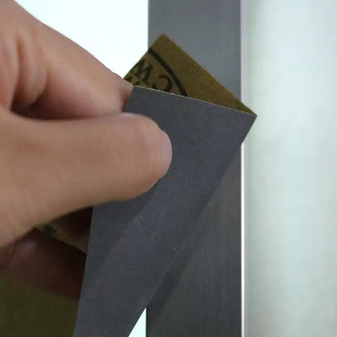 Hand holding Top Notch Wet Dry Sandpaper Set 9 By 11 Inches With Grits 1500 2000 2500 3000 5000 7000 Two Of Each