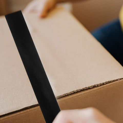 Person applying Heavy Duty Waterproof Repair Tape 50m By 50mm Rubberized Sealant For Leaks on a cardboard box