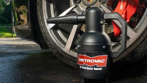 Handheld Car Blower For Detailing And Cleaning, Electric Duster And Dust Buster For Cars next to a car wheel on wet pavement