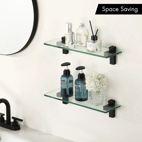 Two Pack 16 Inch Tempered Glass Bathroom Shelves With Matte Black Wall Mount Floating Shelves For Vanity Or Shower Sturdy Modern Storage Easy Install Space Saving Design For Quick Organization displaying toiletries and decor items neatly above a bathroom sink.