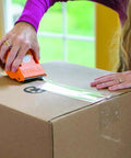 Person using Ultra Tough Packing Tape With Dispenser For Moving And Shipping, Clear 2.83 Inch By 35 Yard, 3.4 Mil Thick on a box