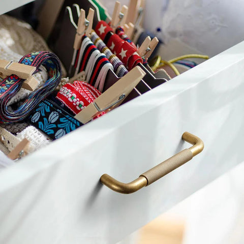 Open drawer with Six Pack 5 Inch Champagne Bronze Knurled Cabinet Pulls With Crosshatch Knurling, showing colorful storage