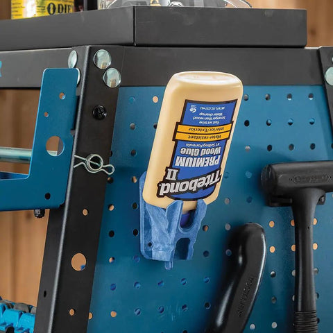 Upside Down Glue Bottle Dock Station With One Handed Access For 4oz 8oz And 16oz Bottles mounted on a pegboard in a workshop.