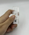 Hand holding a clear Pink Ding Ding Fidget Slider for Adults, compact PEI stress relief tool, designed for soothing haptic feedback.