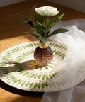 13.5 Inch Mother Of Pearl Lazy Susan Rotating Tray Handcrafted Turntable For Kitchen And Pantry Organization So Chic Rustic Farmhouse Decor Centerpiece Resin Finish with green leaf accents and decorative vase.