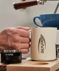 Person using Espresso Tamper Base And Accessories Organizer In Natural Walnut All Size Portafilter Compatible Tamping Station Holder.