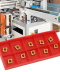 10Pcs CCMT060204 Carbide Inserts for CNC turning tools displayed in red tray with industrial machine in background