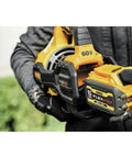 Person holding 60V Max FlexVolt Cordless Handheld Leaf Blower, showing battery compartment, outdoor setting