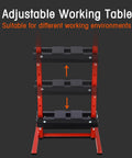 Adjustable working table with a sturdy red frame and black shelves for versatile work environments.