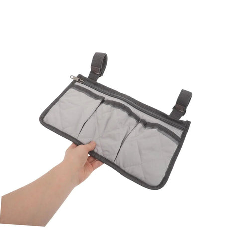 Senior Bedside Rail Organizer With Four Compartments And Cup Holder, Pongee Storage Bag held by hand, showing grey fabric and pockets.