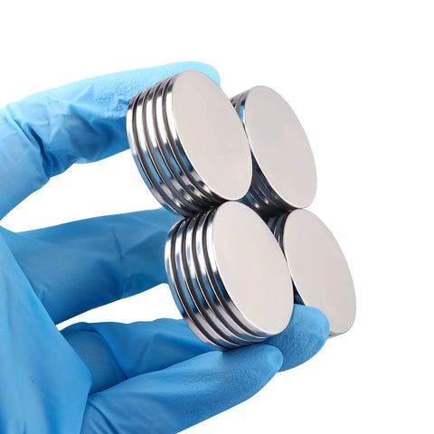 MIKEDE neodymium disc magnets with double-sided adhesive, 1.26 in diameter, four magnets held by a gloved hand