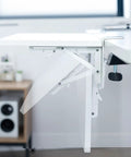 Close-up of a White Clamp On Desk Extender For A Sweet Home Office Upgrade Foldable Desktop Shelf with metal hinge.