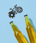 Compact Bicycle Shaped Multitool Keychain For Men Stainless Steel next to beer bottles on blue background