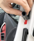 Close-up of black D-shaped hollow rubber weather strip for car door; self-adhesive, 3/8 x 1/4 in, 10 ft