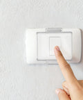 Push Button Switch Cover For Industrial Control Panels Pro Grade Water Resistant Plastic Safety Cap For Start Buttons And Computer Power Switches, hand pressing white wall switch