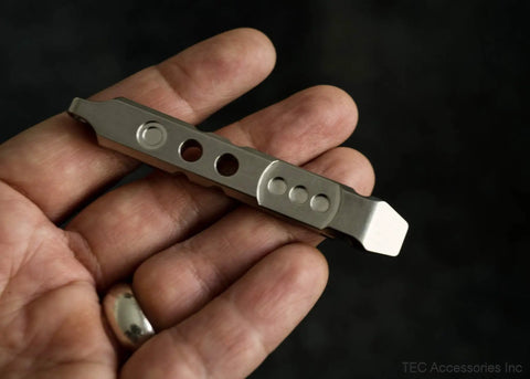 Hand holding Titanium Ti Pry Mini Pry Bar Keychain EDC Pocket Pry Tool With Bottle Opener in 6Al4V titanium construction.