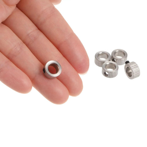 Hand holding nickel-plated Set Screw Shaft Collars 6.05mm Bore, 10mm OD, 5mm Wide alongside a pack of 10 on white background.