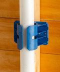 Premium Rockler Dust Right 4 Inch Hose Cradles holding a white PVC pipe, heavy duty ABS clamps for tidy garage setup.