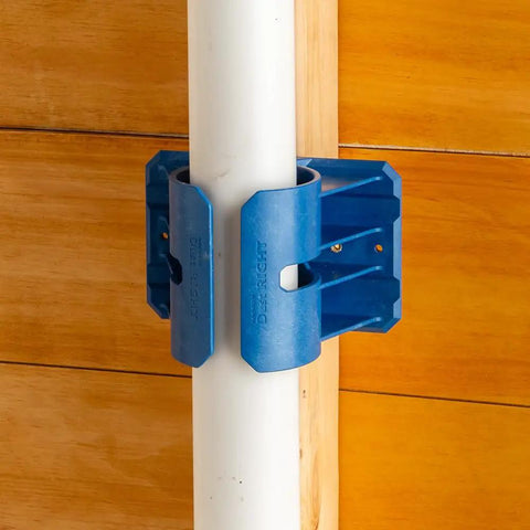Premium Rockler Dust Right 4 Inch Hose Cradles holding a white PVC pipe, heavy duty ABS clamps for tidy garage setup.