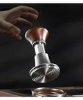 Automatic Spring Loaded Coffee Tamper With Integrated Powder Distributor in hand, showcasing durable metal and wooden design.
