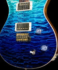 Electric guitar front view with blue quilted finish, two humbucker pickups and gold hardware