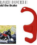 Brake Buckle in red holding motorcycle brake lever, shown on handlebars with clear visor, grass background